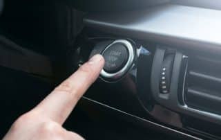Finger pressing car start-stop engine button
