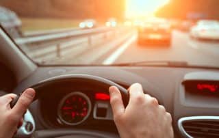 Driver's view of highway traffic at sunset