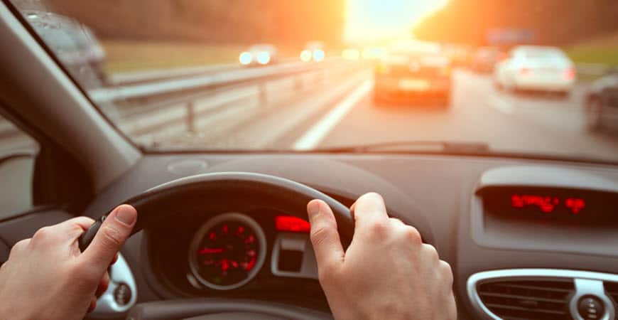 Driver's view of highway traffic at sunset