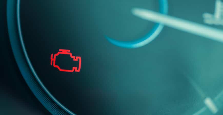Car dashboard with illuminated check engine warning light