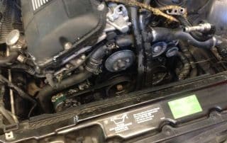 Car engine bay with exposed belts and pulleys