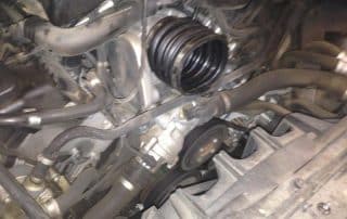 Car engine bay with exposed belts and hoses