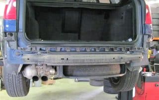 SUV rear lifted with bumper removed in garage