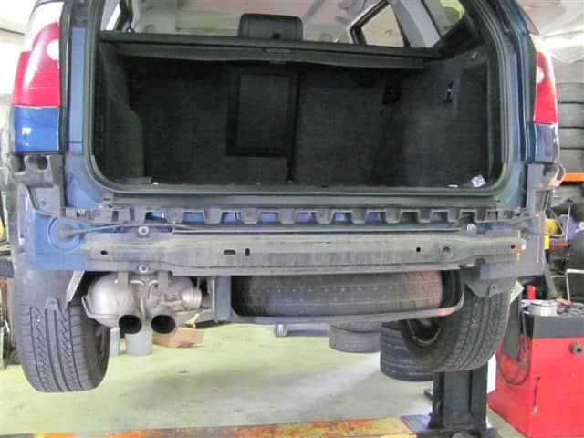 SUV rear lifted with bumper removed in garage