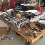 Disassembled car engine parts on workshop table