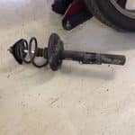 Car suspension strut with coil spring on floor