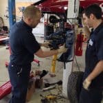 Two mechanics repairing small aircraft landing gear