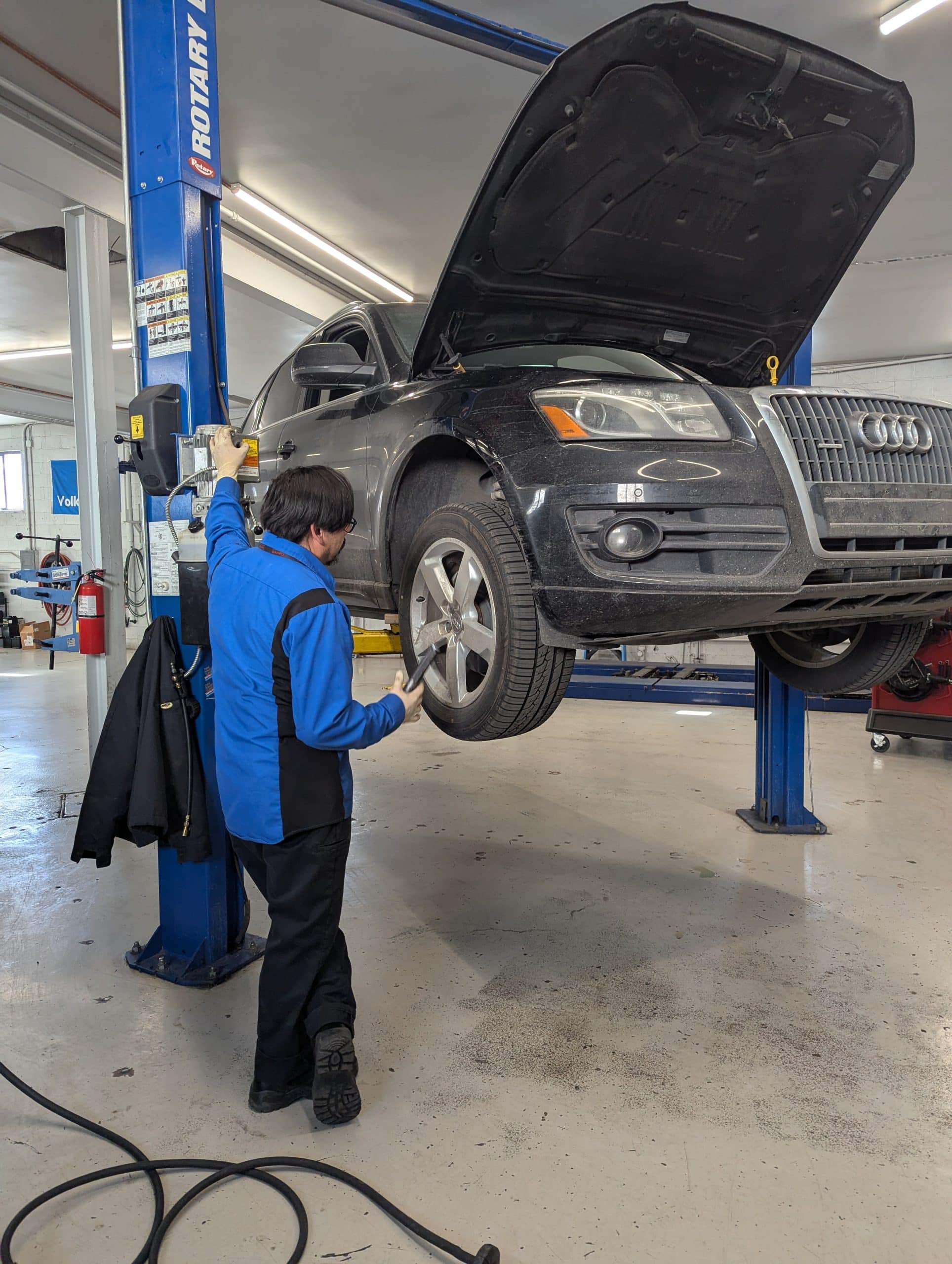 Mechanic inspecting SUV on hydraulic lift