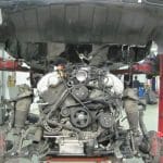 Car on lift with exposed engine in workshop