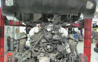 Car on lift with exposed engine in workshop