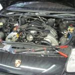 Open Porsche hood with exposed engine and tools