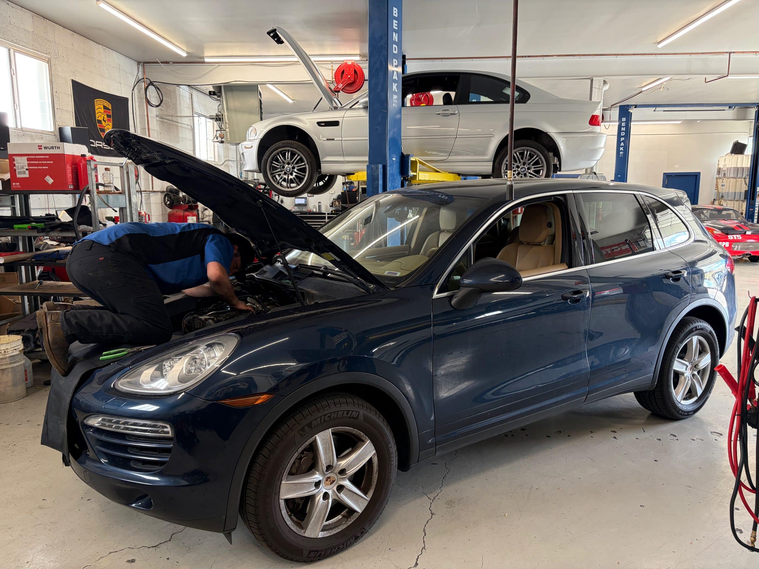 Mechanic repairing SUV in auto shop garage