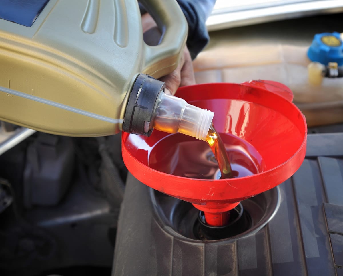European Auto Oil Change in Denver image Pouring motor oil into car engine funnel