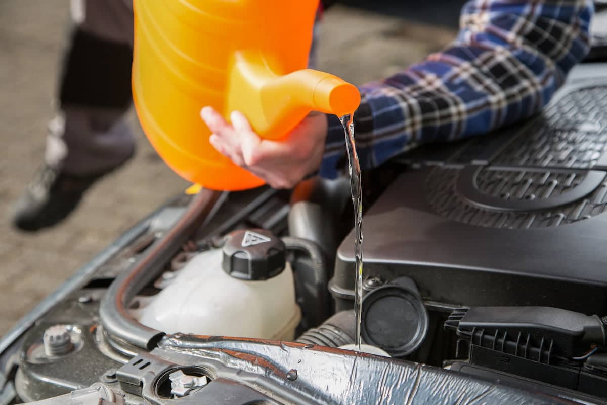 Pouring coolant into car engine reservoir