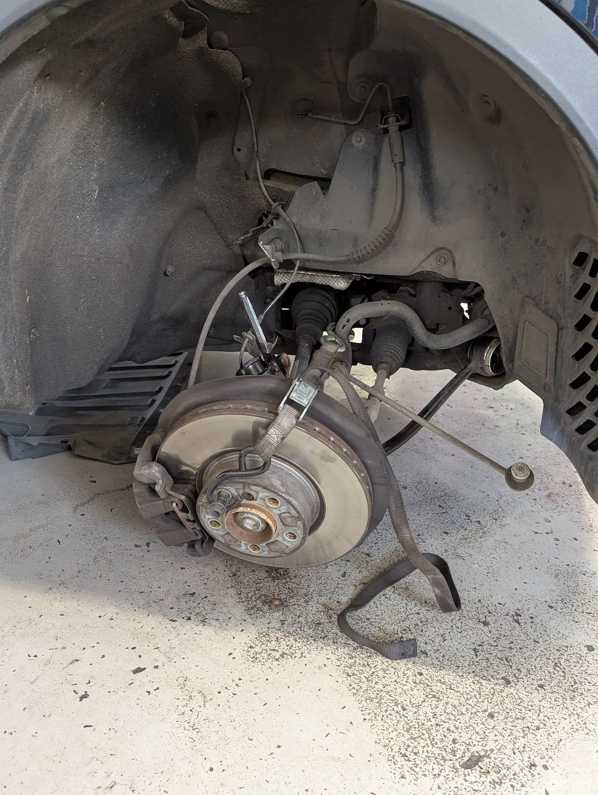 European Auto Suspension Repair in Denver image Car brake rotor and suspension with wheel removed