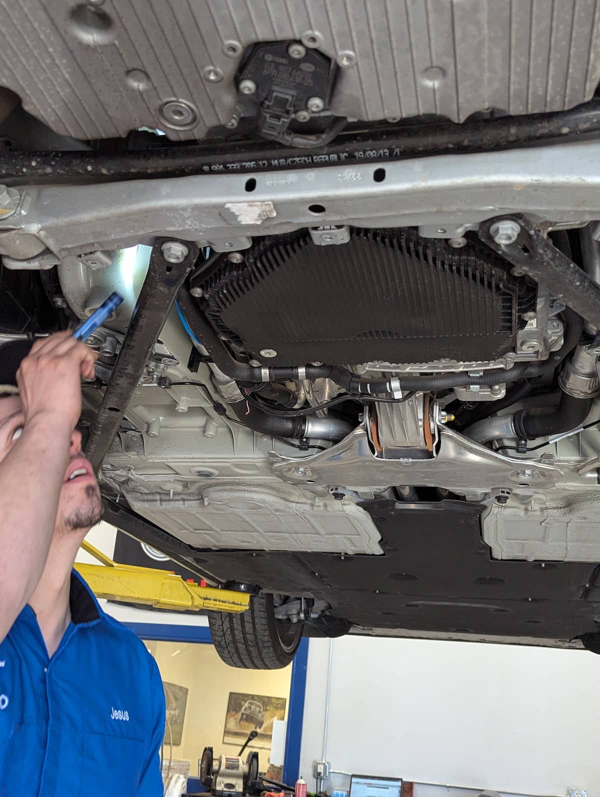 European Auto Transmission Repair in Denver image Mechanic inspecting underside of car on lift