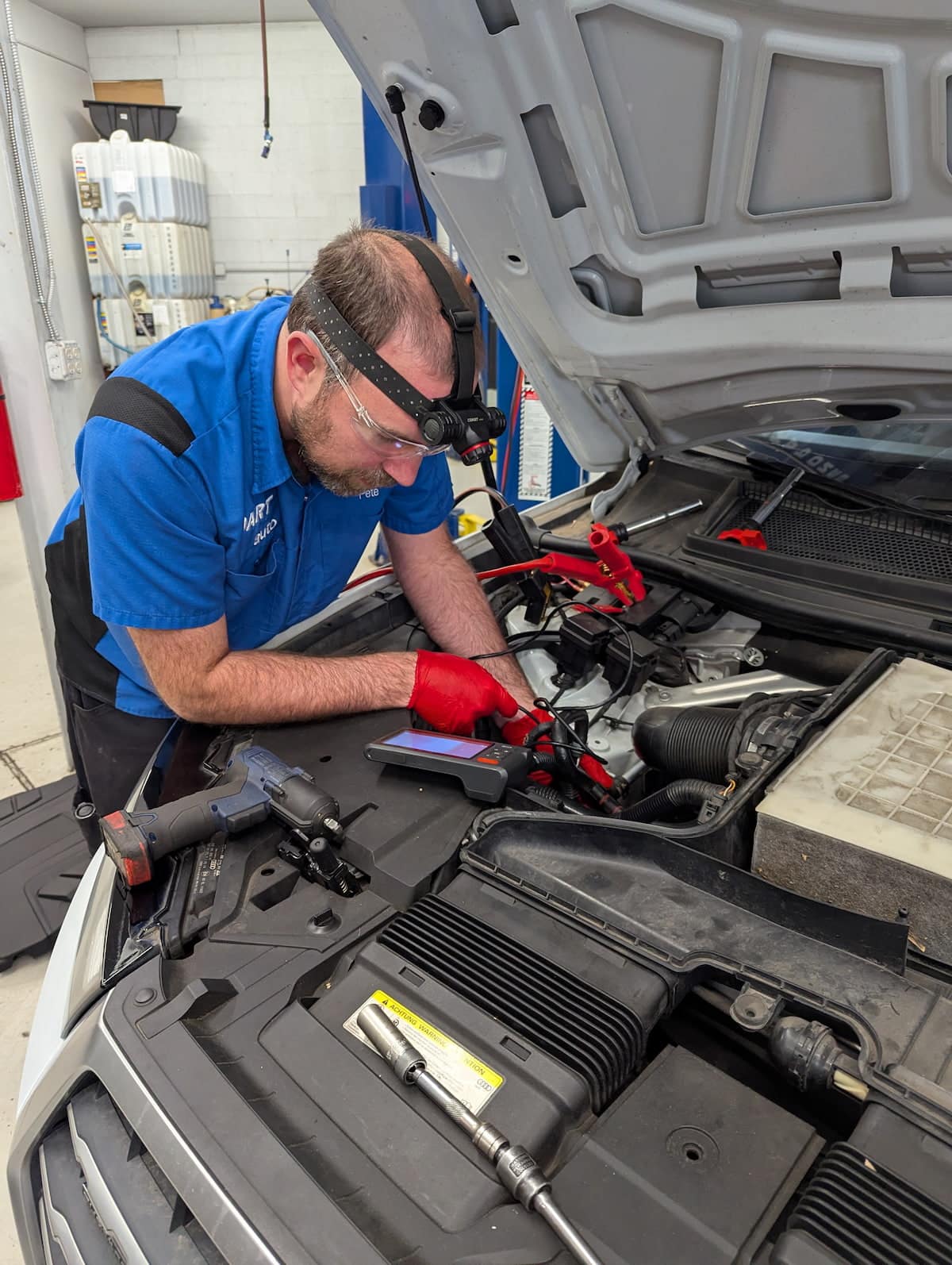 Mechanic diagnosing car engine in auto shop