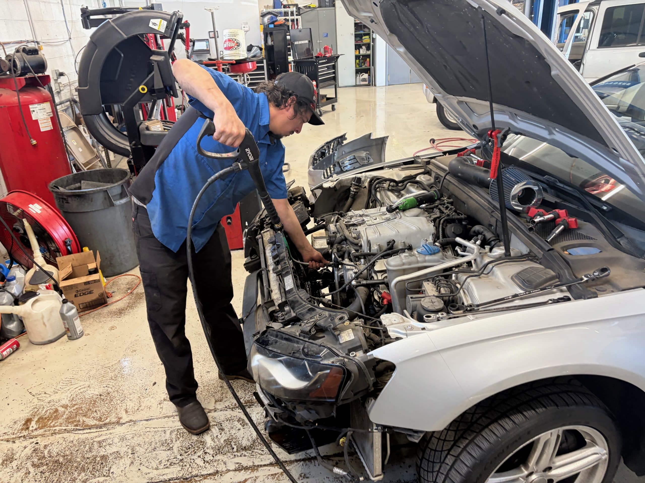 Mechanic cleaning car engine in auto shop