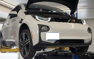 White electric car on lift in garage