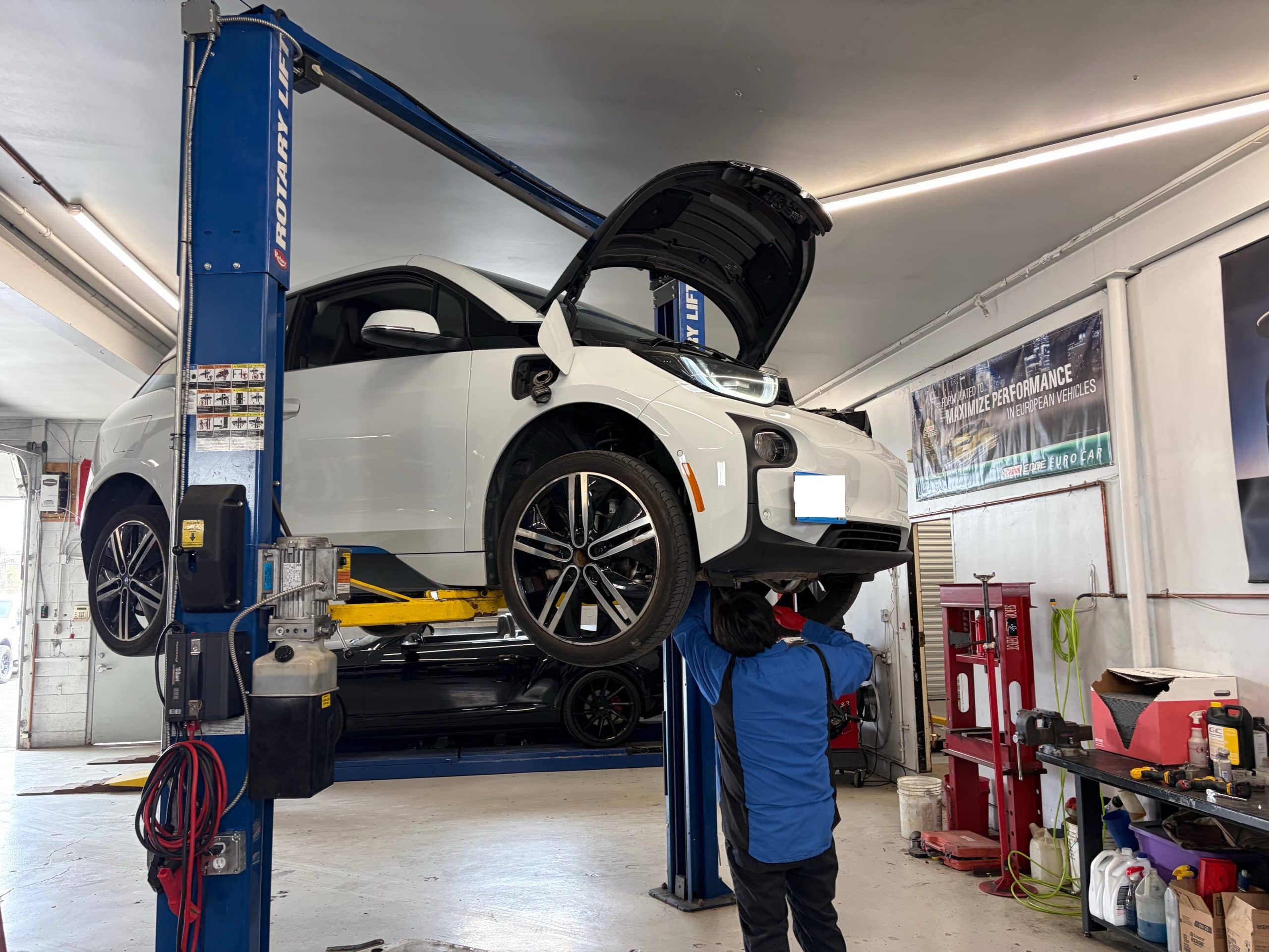 White electric car on lift in auto shop