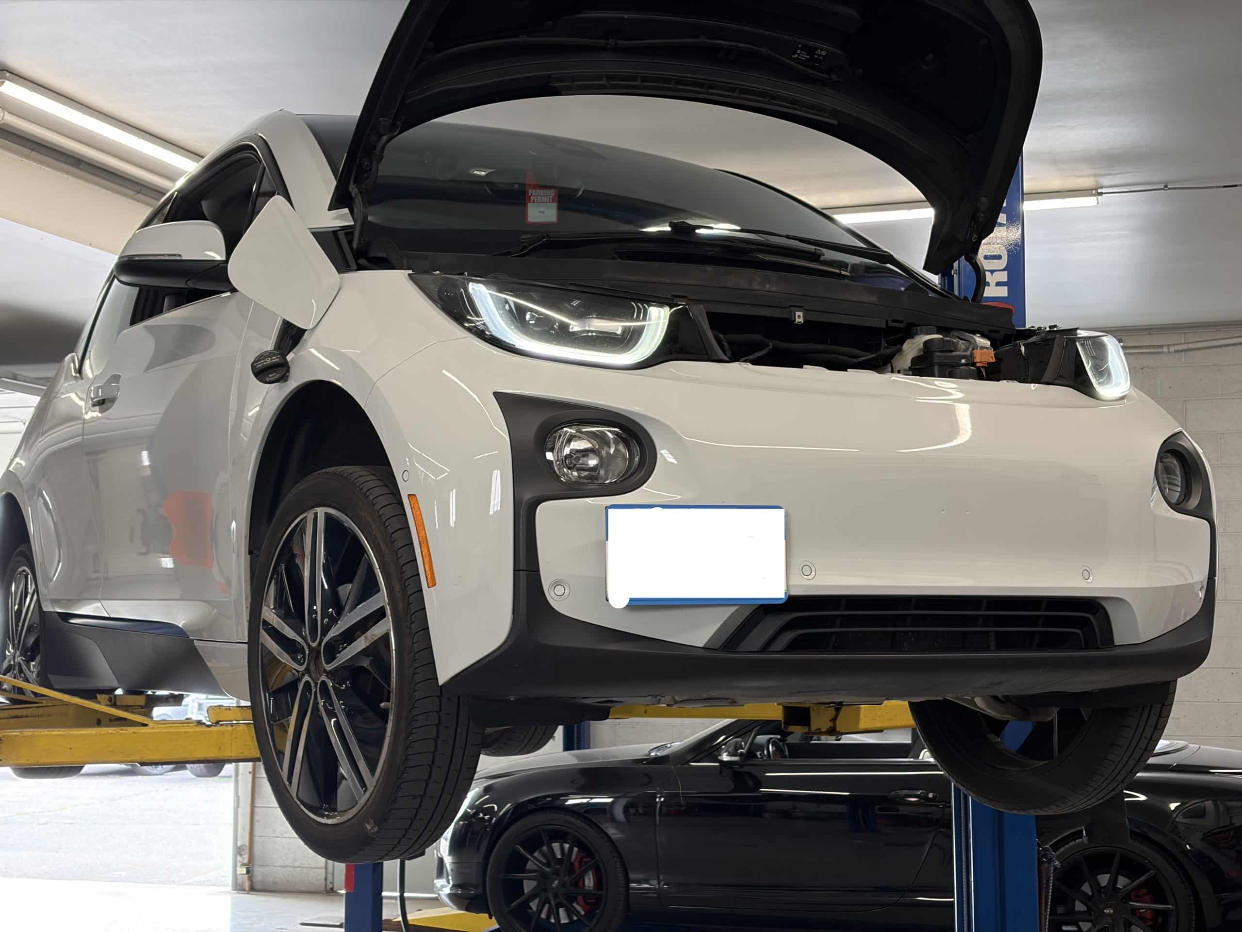 White electric car on lift in garage