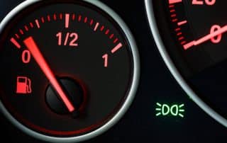 Car fuel gauge near empty on dashboard