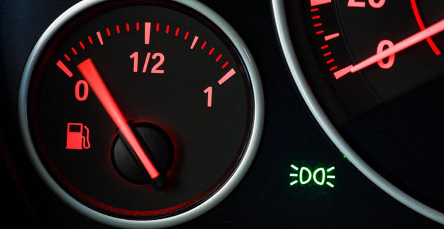 Car fuel gauge near empty on dashboard