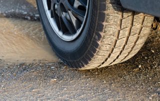 Car tire on wet gravel road