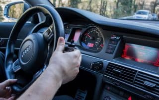 Driver holding steering wheel inside Audi car