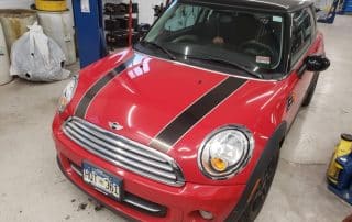 Red Mini Cooper with black racing stripes