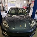 Gray Porsche sports car inside auto repair shop