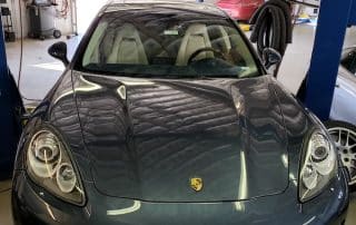 Gray Porsche sports car inside auto repair shop
