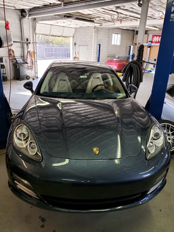 Gray Porsche sports car inside auto repair shop