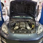 Car engine bay with hood open in garage