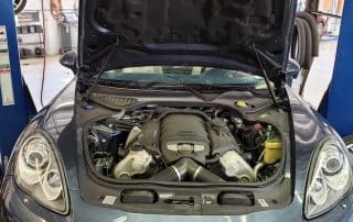 Car engine bay with hood open in garage
