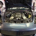 Car engine bay with hood open in garage