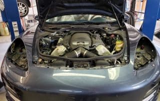 Car engine bay with hood open in garage