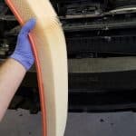 Gloved hand holding car engine air filter