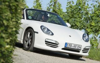 White convertible sports car on vineyard road
