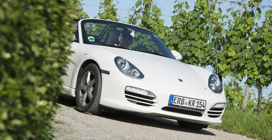 White convertible sports car on vineyard road