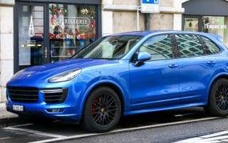 Blue Porsche SUV parked on city street
