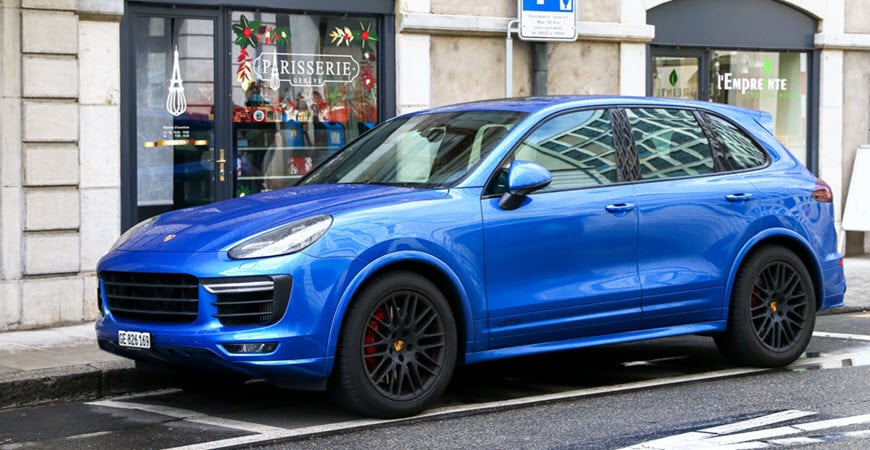 Blue Porsche SUV parked on city street