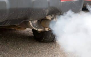 Car exhaust pipe emitting thick white smoke