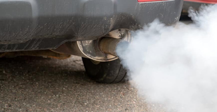 Car exhaust pipe emitting thick white smoke