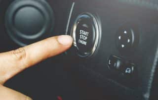 Finger pressing car start stop engine button