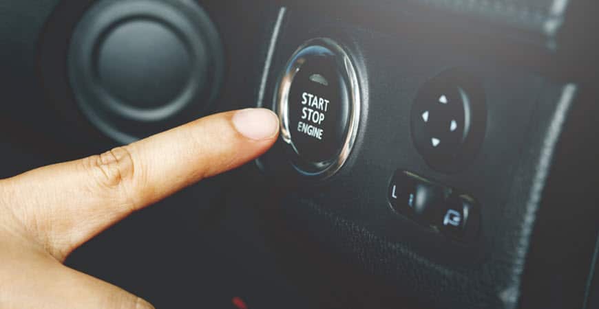 Finger pressing car start stop engine button