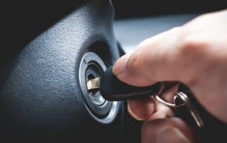 Hand inserting car key into ignition