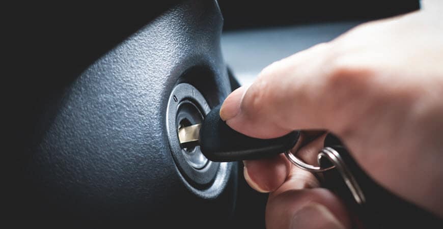 Hand inserting car key into ignition