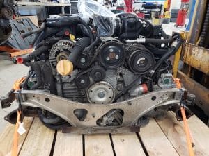 Car engine secured on wooden pallet in workshop