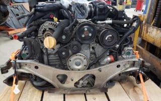 Car engine secured on wooden pallet in workshop